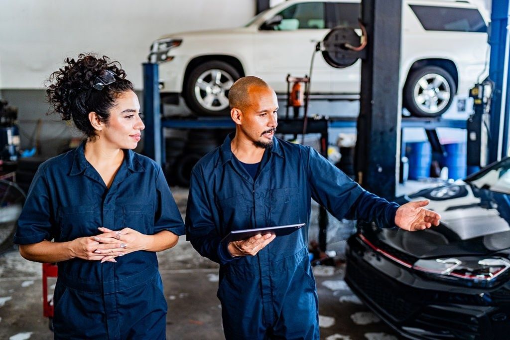 Mechanics talking and walking at auto repair shop